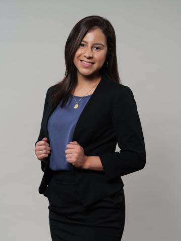 Ana Manzano wearing a blue shirt and black suit